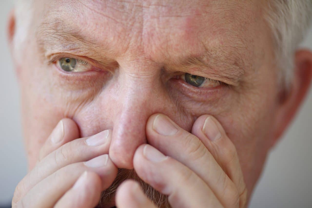 Close-up of a person holding their nose