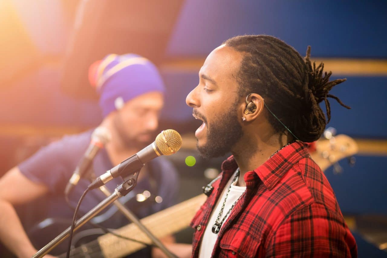 A person singing into a microphone on a stage
