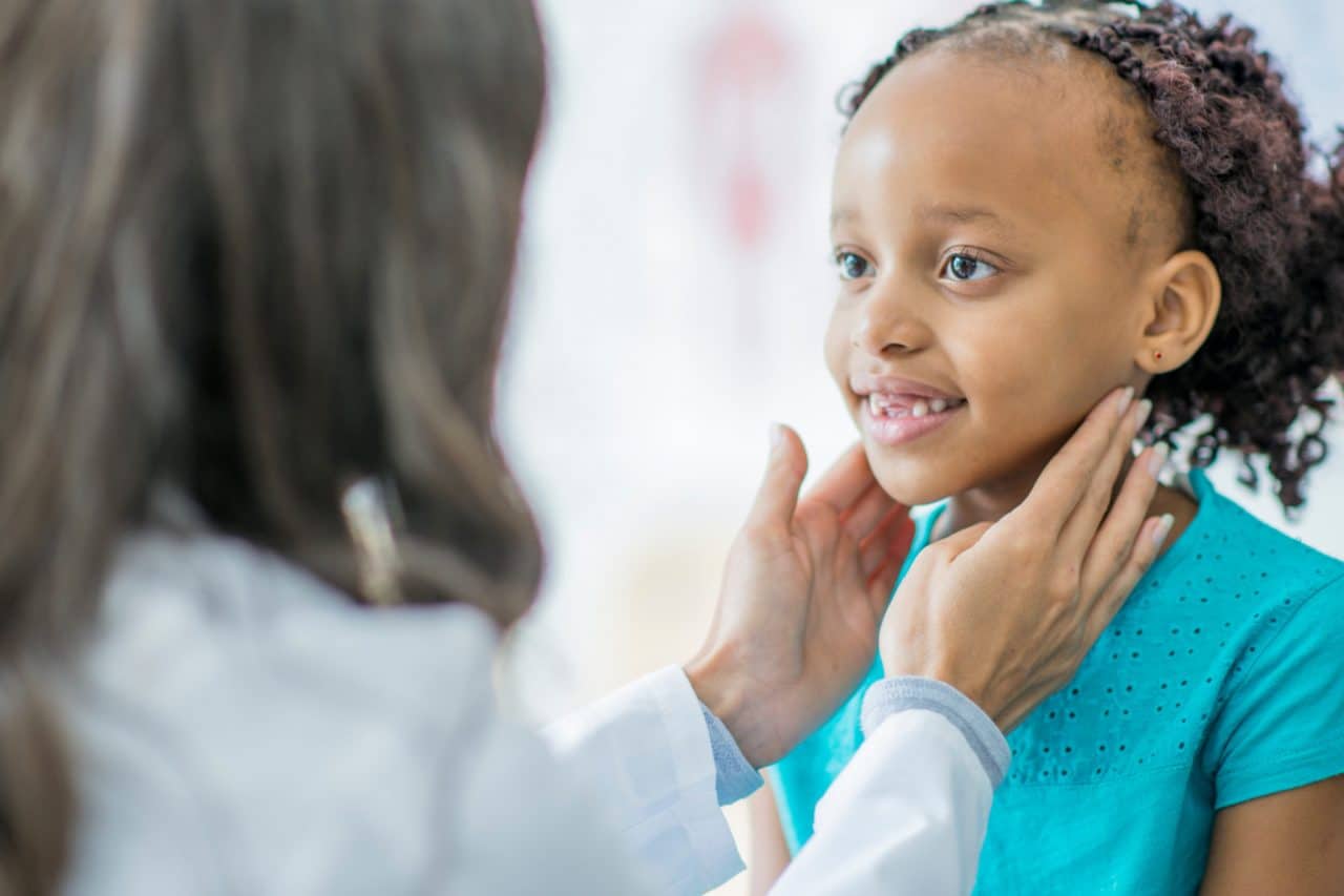 A child having their throat examined by touch