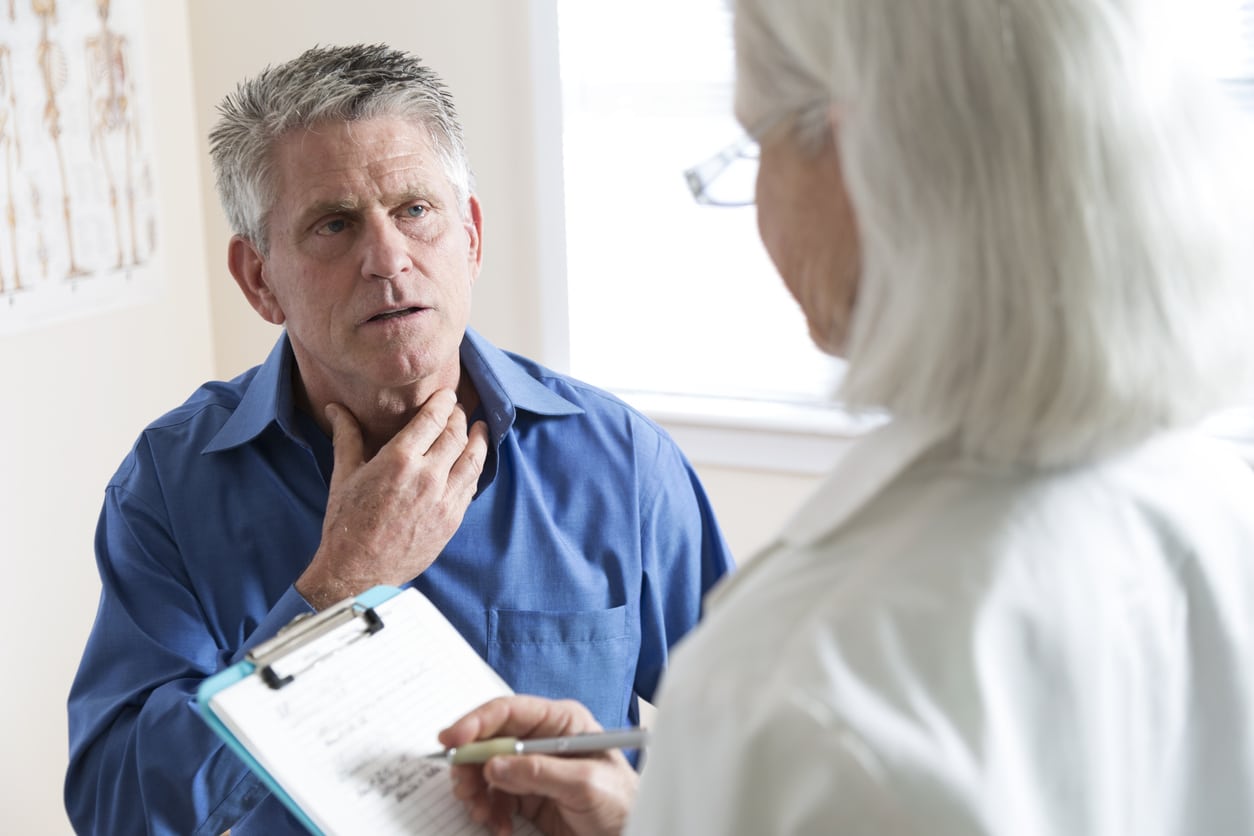 Man with a sore throat talks to his doctor