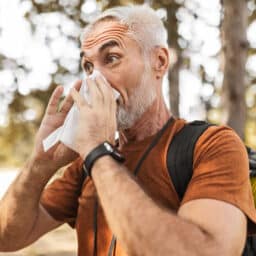 Senior Man Hiker Hiking Through Woods Using Handkerchief